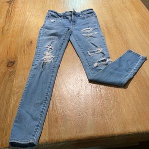 Light wash blue Jean pants with holes.